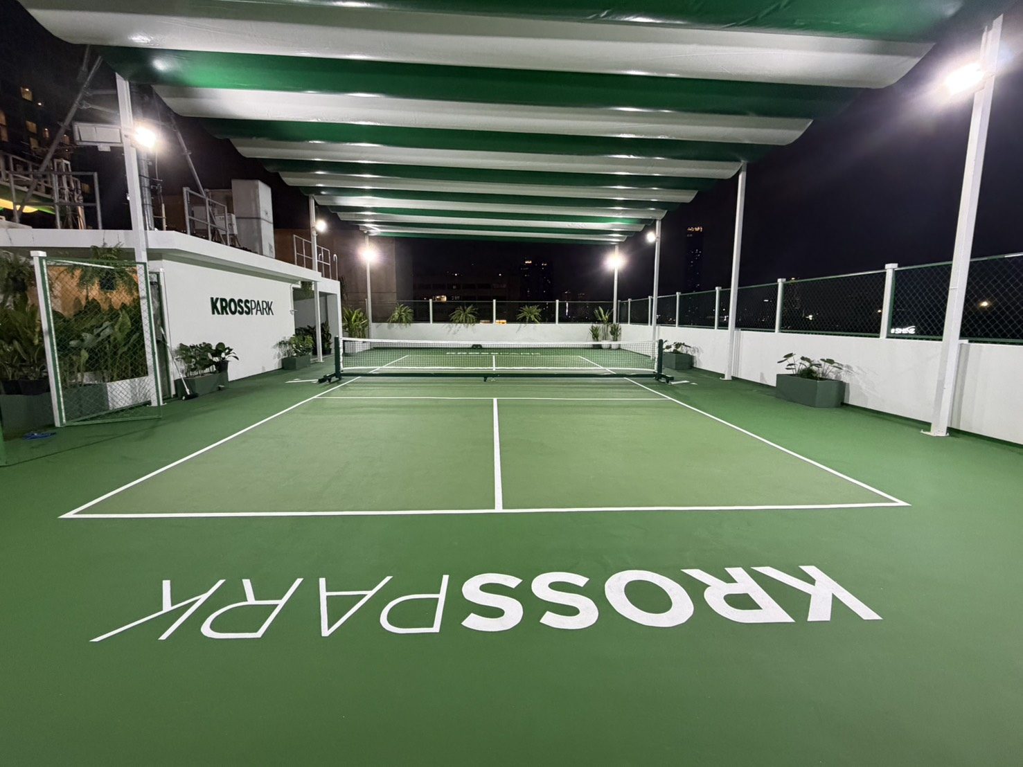KROSS PARK rooftop pickleball court at night under the retractable roof